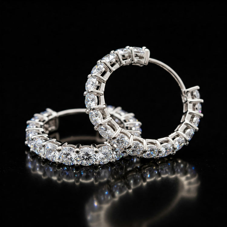 Pair of sparkling Feelori CZ Bali Hoop earrings set in polished metal on a reflective surface - modern Indian jewelry.