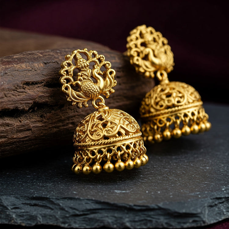 Macro close-up showcasing the intricate traditional carvings and matte gold finish of a Feelori Nakshi earring.
