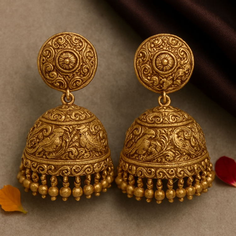 Close-up of FeelOri Nakshi Matte Jhumka earring showing intricate handcrafted details, styled elegantly on stone with silk and flower petals.