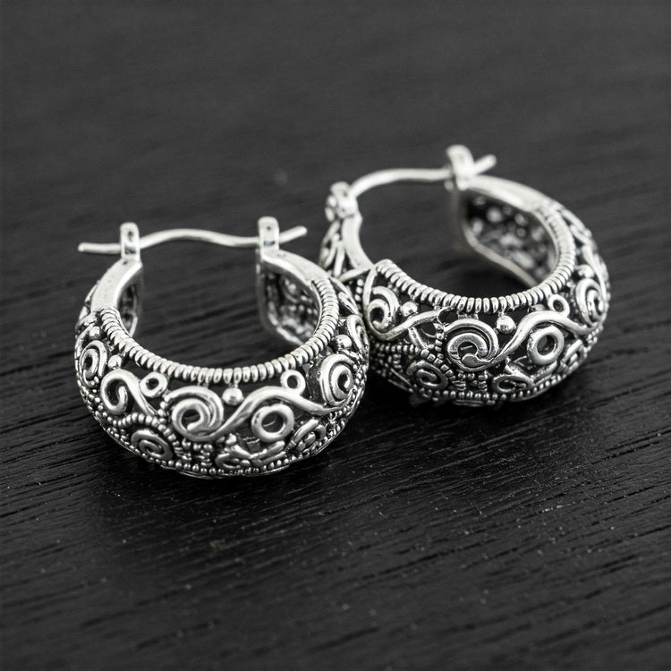 Pair of Feelori Silver Bali Hoop earrings with intricate traditional detailing on dark wood - classic Indian jewelry.