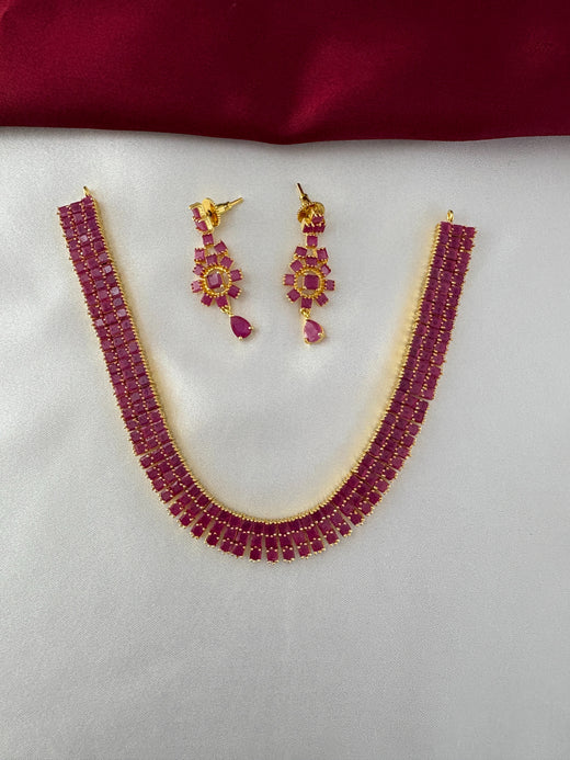 FeelOri Gold Plated Ruby Bar Necklace & Earring Set - Top view showcasing the full elegant set on a white silk backdrop.