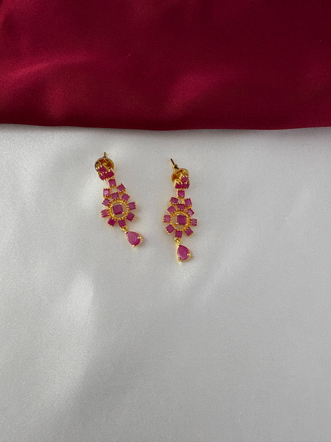 FeelOri Gold Plated Ruby Floral Earrings - Close-up view highlighting the intricate flower arrangement and dangling ruby-hued teardrop design.