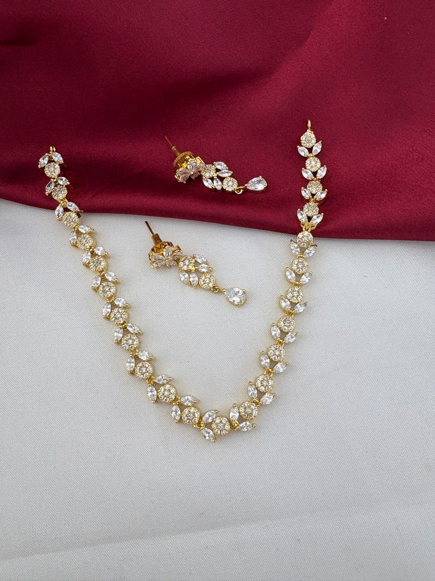 FeelOri Bollywood Glam AD Stone Statement Choker Set with matching earrings, full view on white and maroon background.