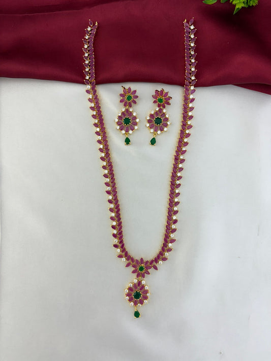 Overall view of the Feelori Celestial Cascade Rainbow AD Long Necklace & Earring Set on a contrasting white and maroon background.