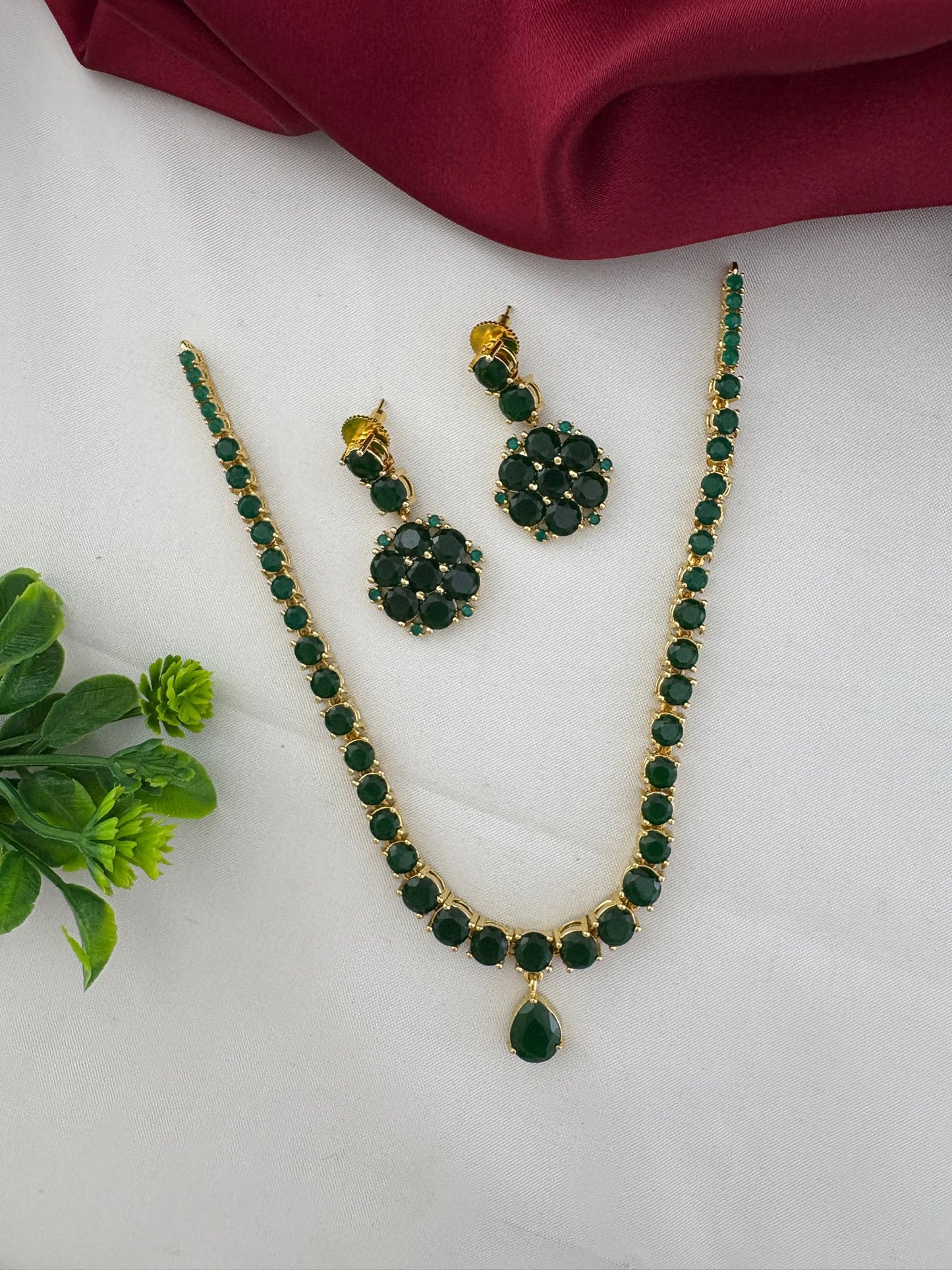 FeelOri Deccan Spring Emerald Short Necklace Set styled with elegant fabric and a touch of greenery, showcasing the complete set.