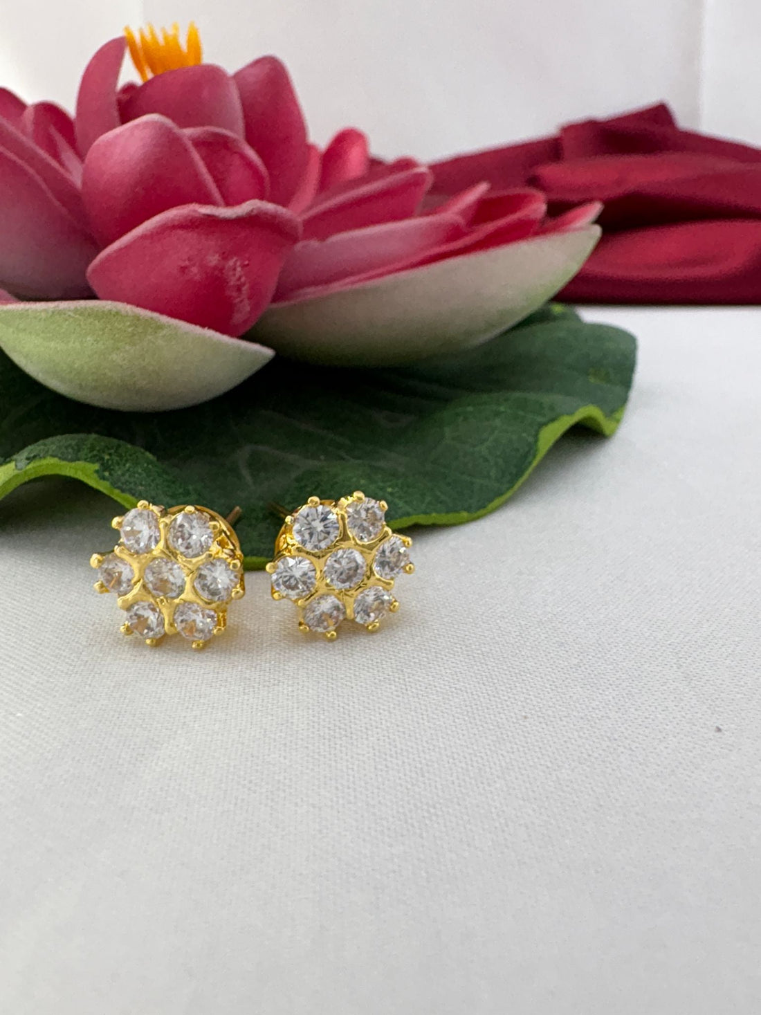 FeelOri gleam white emerald-cut AD stud earrings styled with a lotus prop