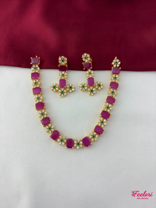 FeelOri Gold Plated Ruby Emerald Floral Necklace Set - flat lay view showcasing the full necklace with rectangular ruby segments and matching floral cluster earrings.