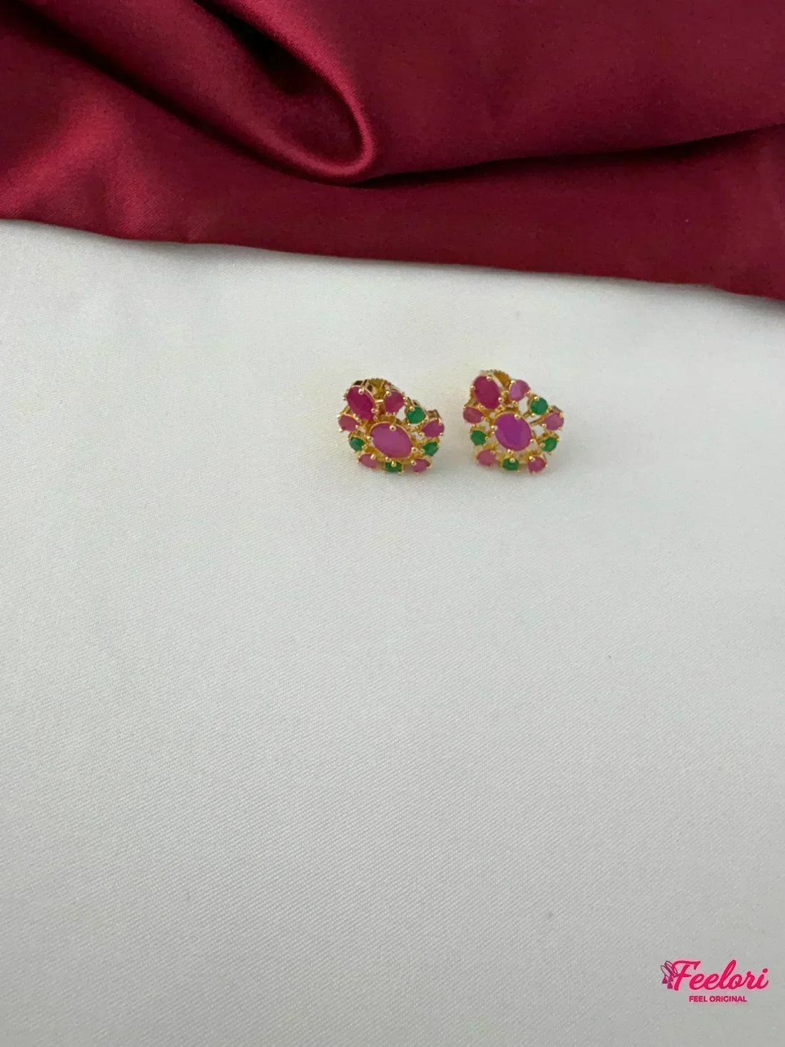 FeelOri Gold Plated Ruby Emerald Earrings - Close-up view of a single earring, highlighting the intricate petal arrangement of Ruby CZ and emerald stones.