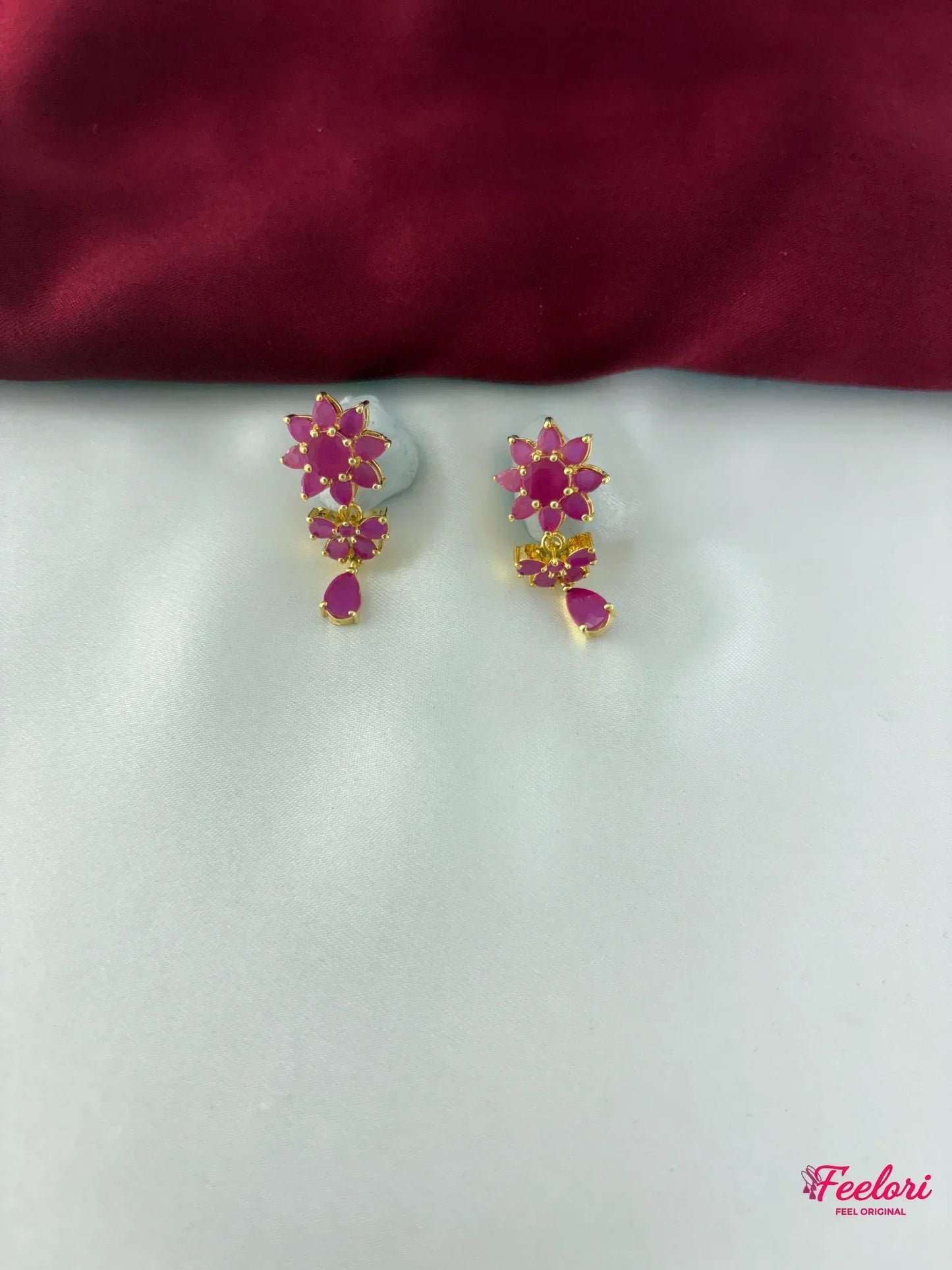 FeelOri Gold Plated Ruby Floral Motif Earrings - Close-up view of the intricate floral cluster earrings with a dangling ruby-hued tear drop.