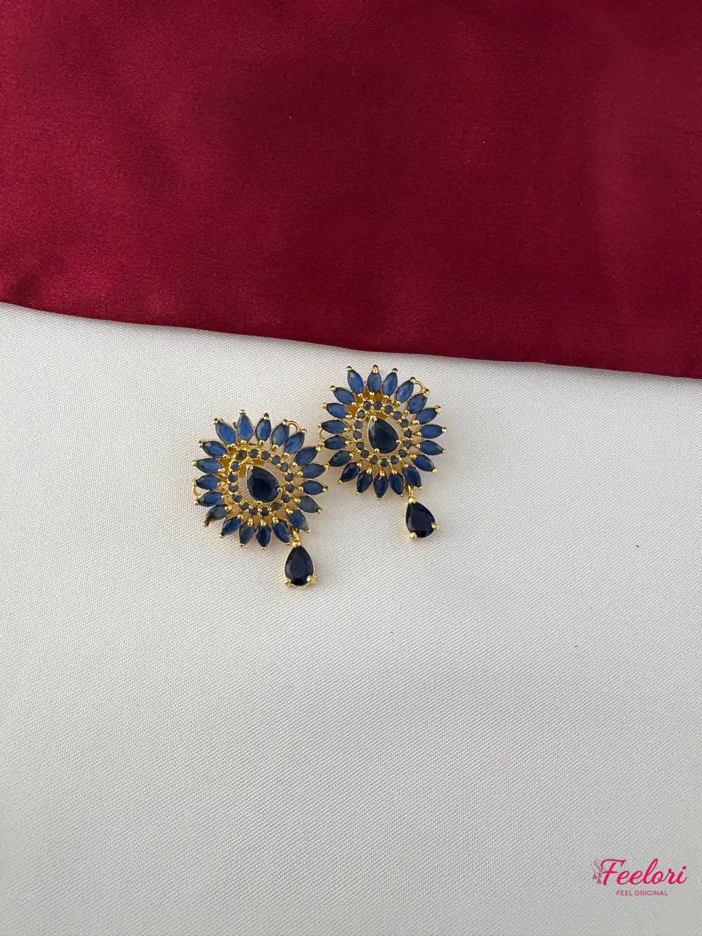 FeelOri Gold Plated Sapphire Floral Earrings - Close-up view revealing detailed stone setting and dangling teardrop accent.