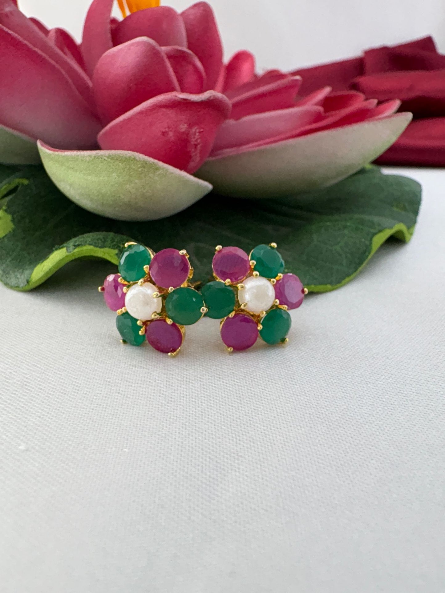 FeelOri jewel tone multi-color AD stud earrings elegantly styled with lotus showcasing premium gemstone colors