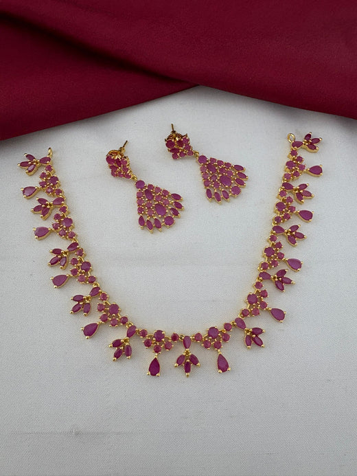 FeelOri Majestic Ruby-Tone CZ Short Necklace Set with earrings laid flat. Gold-plated ruby stone jewelry for Kerala receptions by FeelOri.