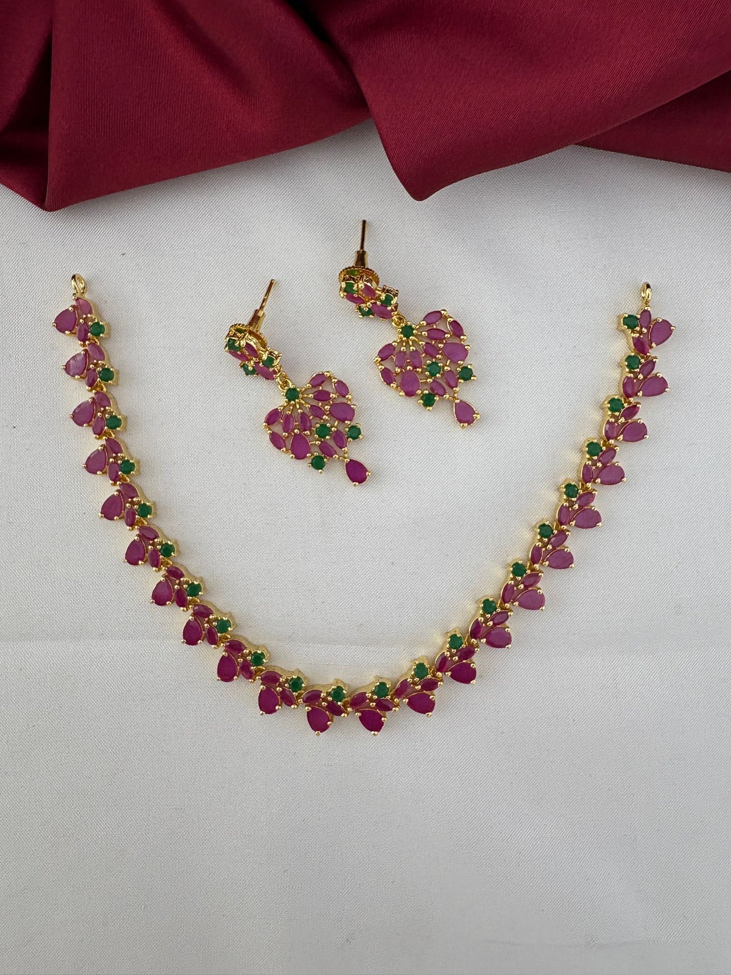 Overall layout of the FeelOri Mysore Vasantham short necklace with ruby and emerald stones, shown with matching earrings.