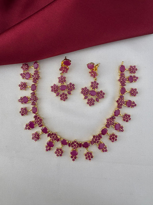 FeelOri Nakshi Work Original Ruby Short Necklace and Earrings Set - Telangana Art. Full view of the ruby jewelry set on a white and maroon background.