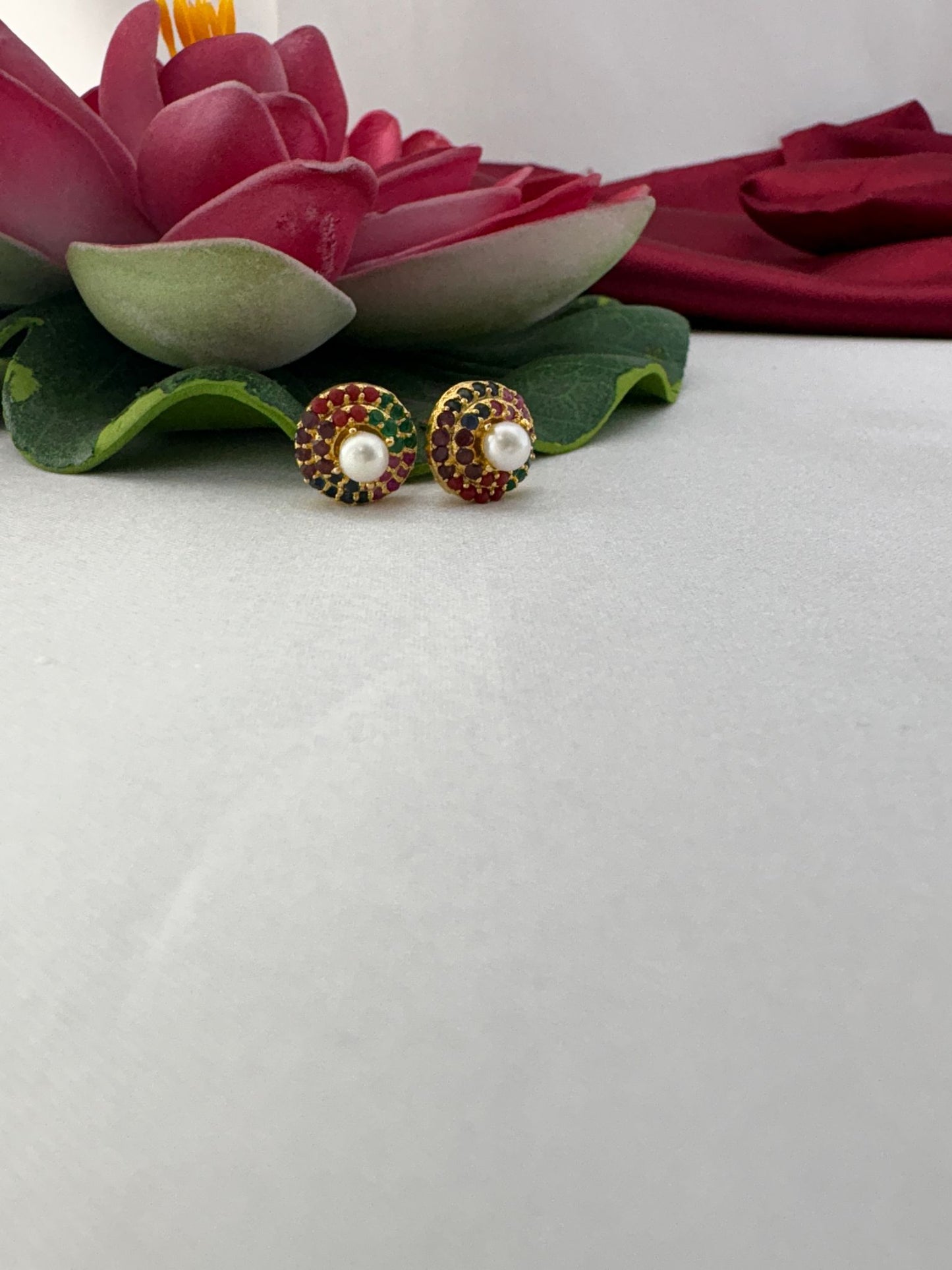FeelOri Navaratna AD stud earrings styled with lotus flower highlighting traditional Indian gemstone significance