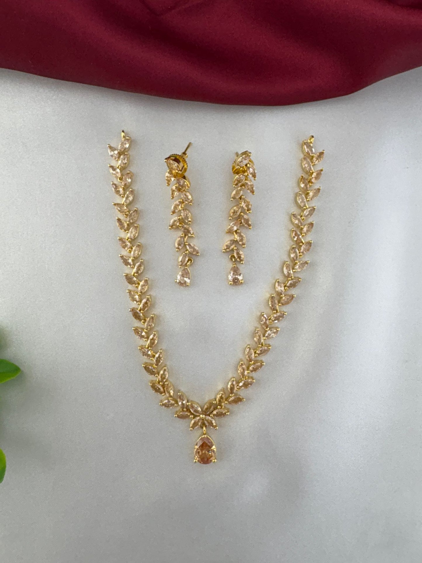 feelori Regal Gold Filigree AD Short Choker Set - Royal Touch - Full view of necklace and earrings on satin background