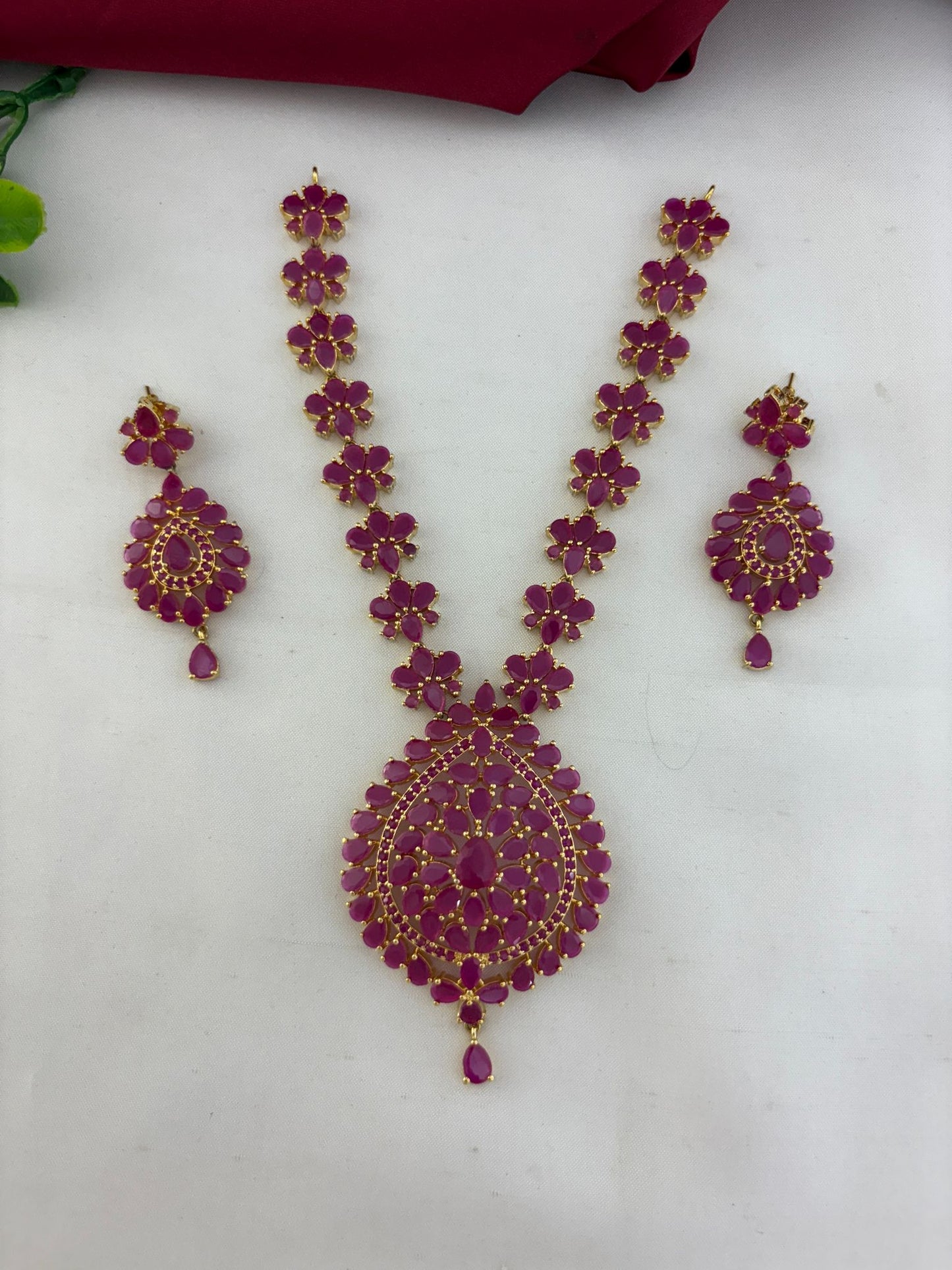 FeelOri Minimalist Original Ruby Short Necklace Set with matching earrings, featuring vibrant ruby stones and gold-tone finish, displayed on a light surface.