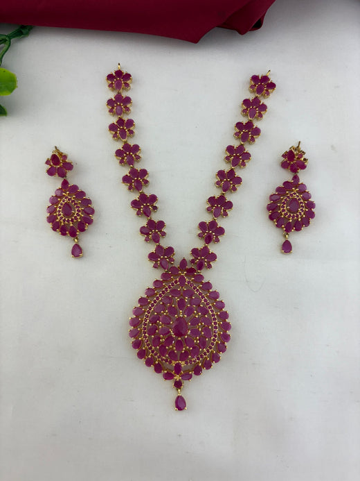 FeelOri Minimalist Ruby-Tone CZ Short Necklace Set with matching earrings, featuring vibrant ruby stones and gold-tone finish, displayed on a light surface.