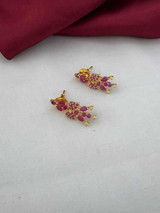 FeelOri Bridal Wear Original Ruby Short Necklace Set - South India Special - Close-up of ruby stud earrings on a white and maroon background.