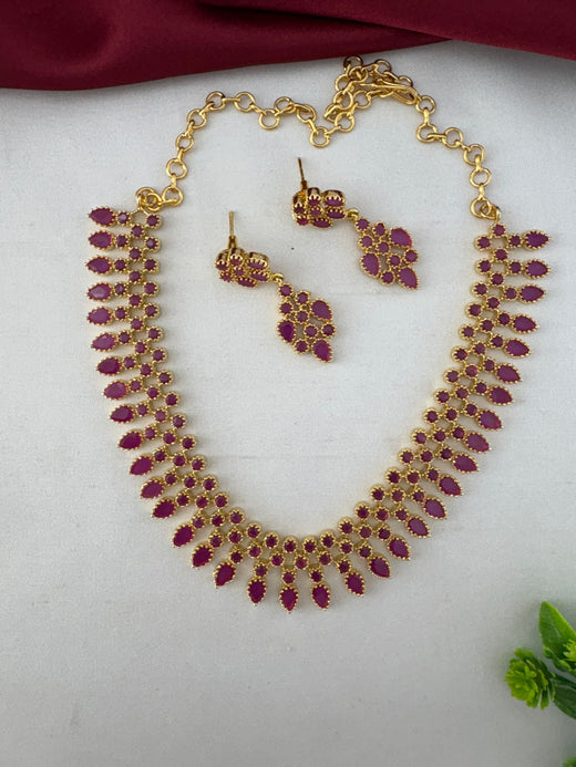 FeelOri Festive Wear Ruby-Tone CZ Short Necklace Set with matching earrings, flat lay view. Perfect for Indian Celebrations, featuring gold-tone design and vibrant ruby stones.