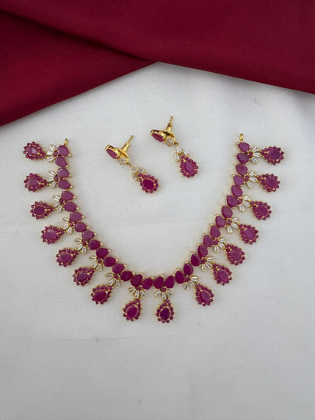 Main image of FeelOri South Indian Ruby-Tone CZ Short Necklace Set, including earrings. Features vibrant ruby stones, designed for Pattu Sarees.
