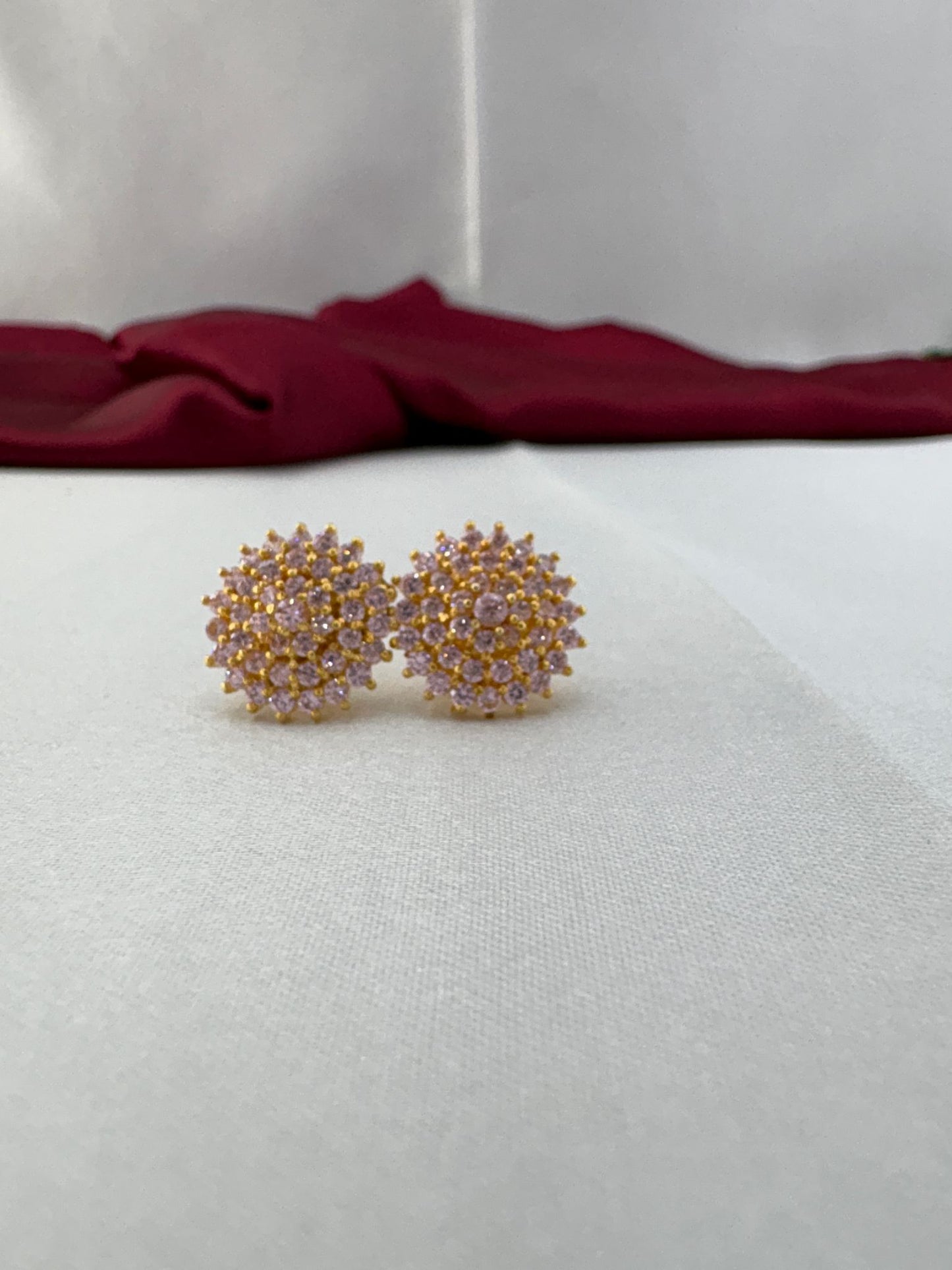FeelOri Sweetheart baby pink AD stud earrings pair on white fabric showing delicate cluster design with gold setting