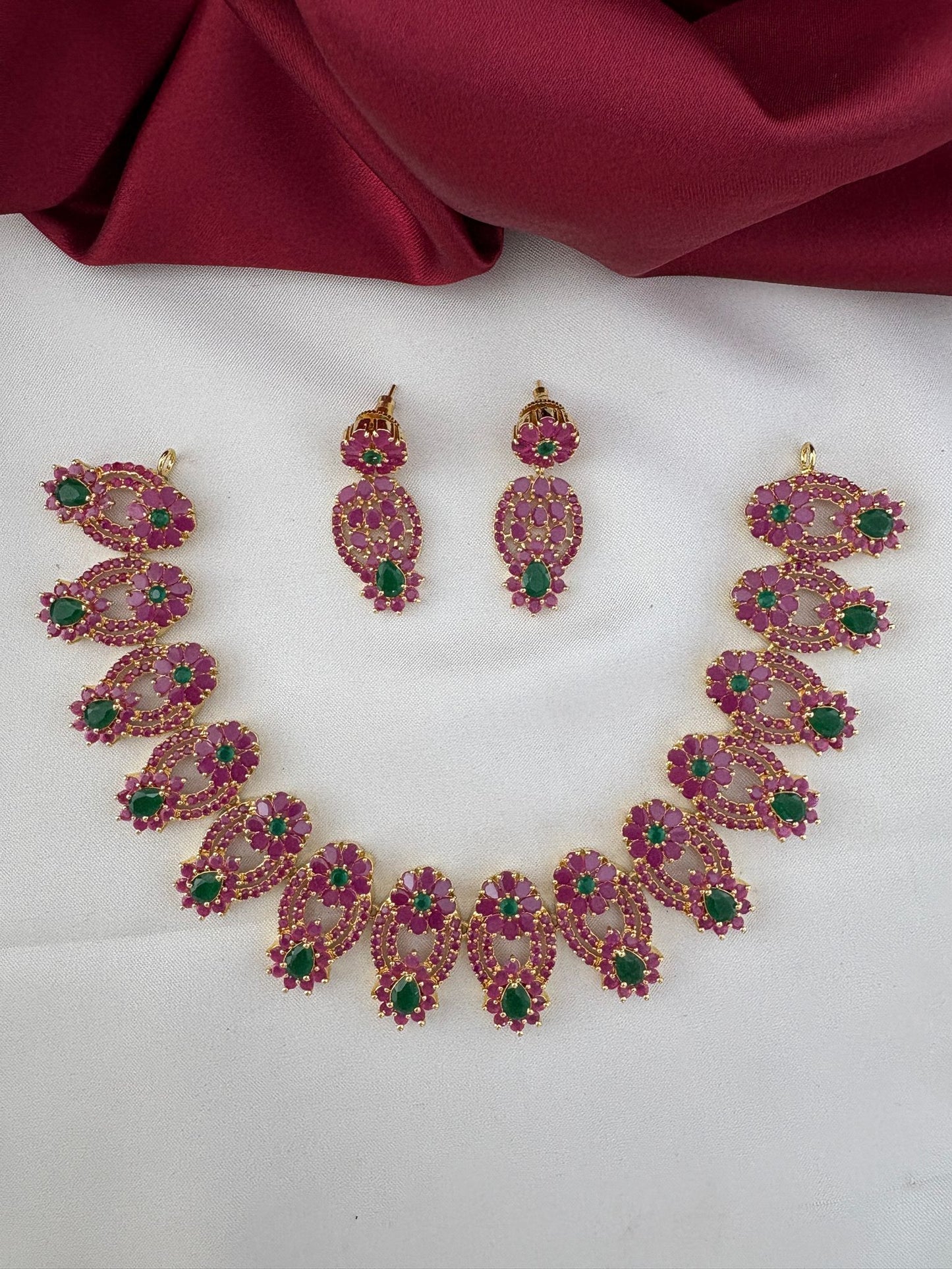 FeelOri Vibrant Fusion Ruby & Emerald Short Necklace and Earrings Set displayed on a white background with a burgundy silk drape.