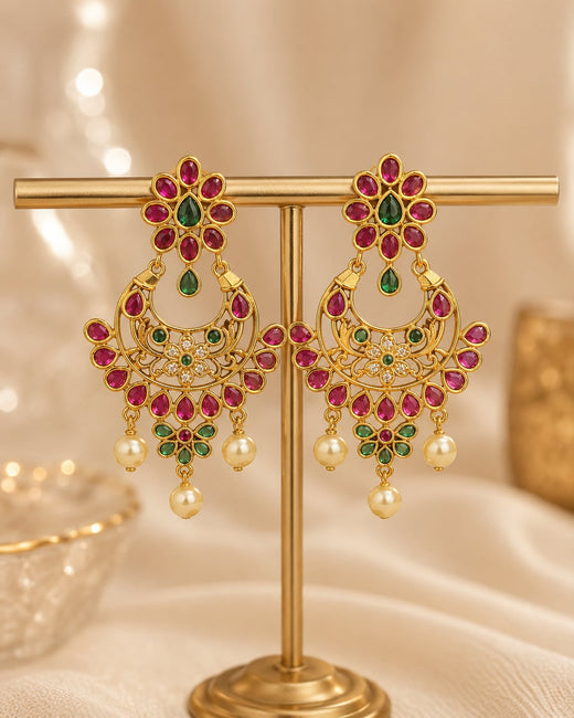 FeelOri gold-plated ruby and emerald earrings on jewellery display