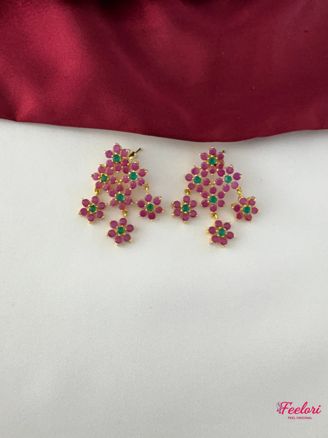 FeelOri Gold Plated Floral Ruby Emerald Earrings - Close-up view of the intricate chandelier earrings, highlighting the Ruby CZ-like and emerald-like stones set in a delicate floral cluster design.