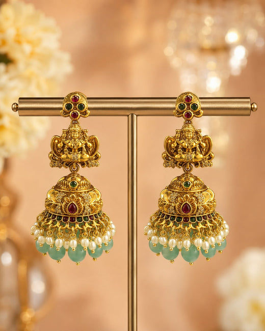 FeelOri gold-plated ruby and emerald jhumka earrings on jewellery display