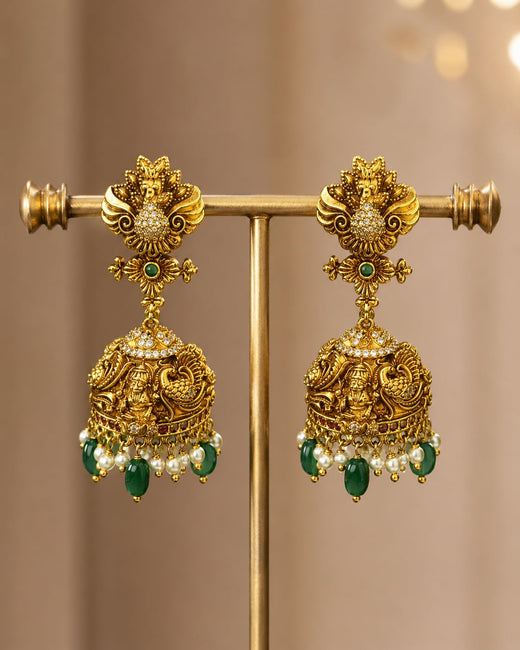FeelOri gold-plated ruby and emerald jhumka earrings on jewellery display