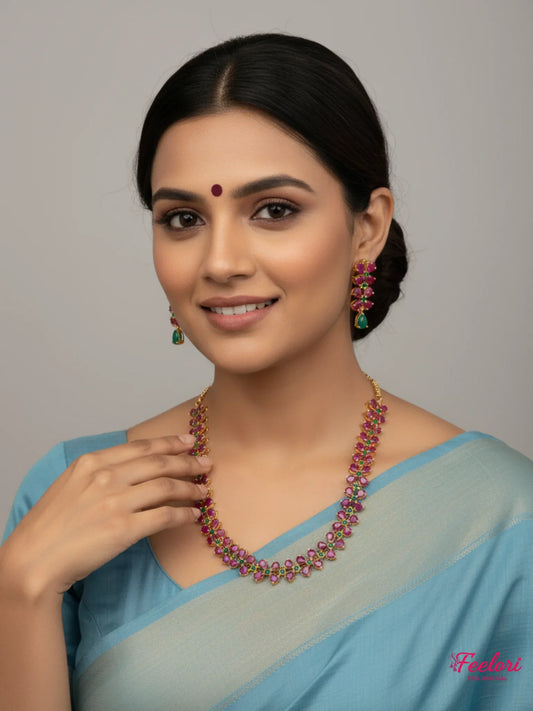 FeelOri Gold Plated Ruby Emerald Leaf Motif Necklace Set - Model wearing set with blue traditional saree, smiling.