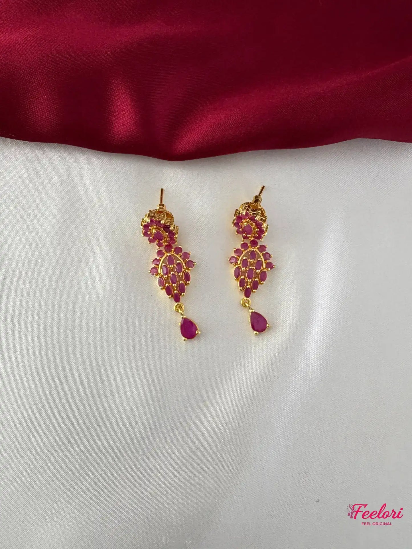 FeelOri Gold Plated Ruby Floral Earrings - Close-up view highlighting the detailed floral pattern and dangling tear-drop ruby-hued stone.