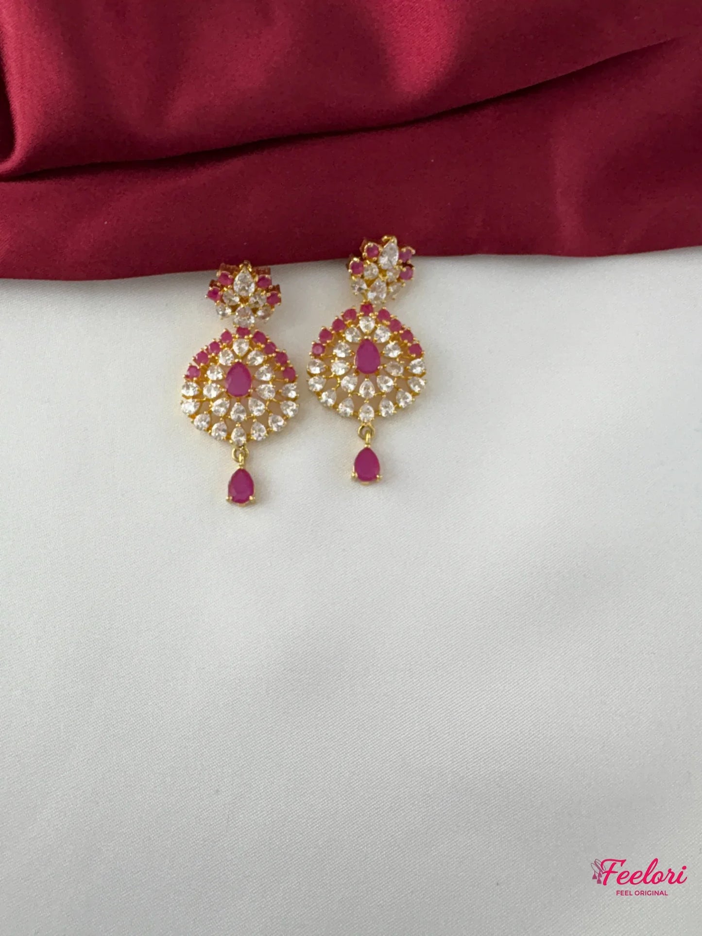 FeelOri Gold Plated Ruby Flower Halo Earrings - Close-up view of one earring, highlighting the vibrant ruby-hued stone and surrounding clear accents with a delicate drop.