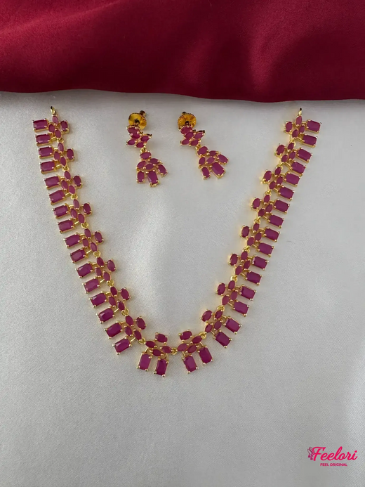 FeelOri Gold Plated Ruby Cluster Necklace Set - Full view showcasing the matching necklace and drop earrings on a white and maroon background.