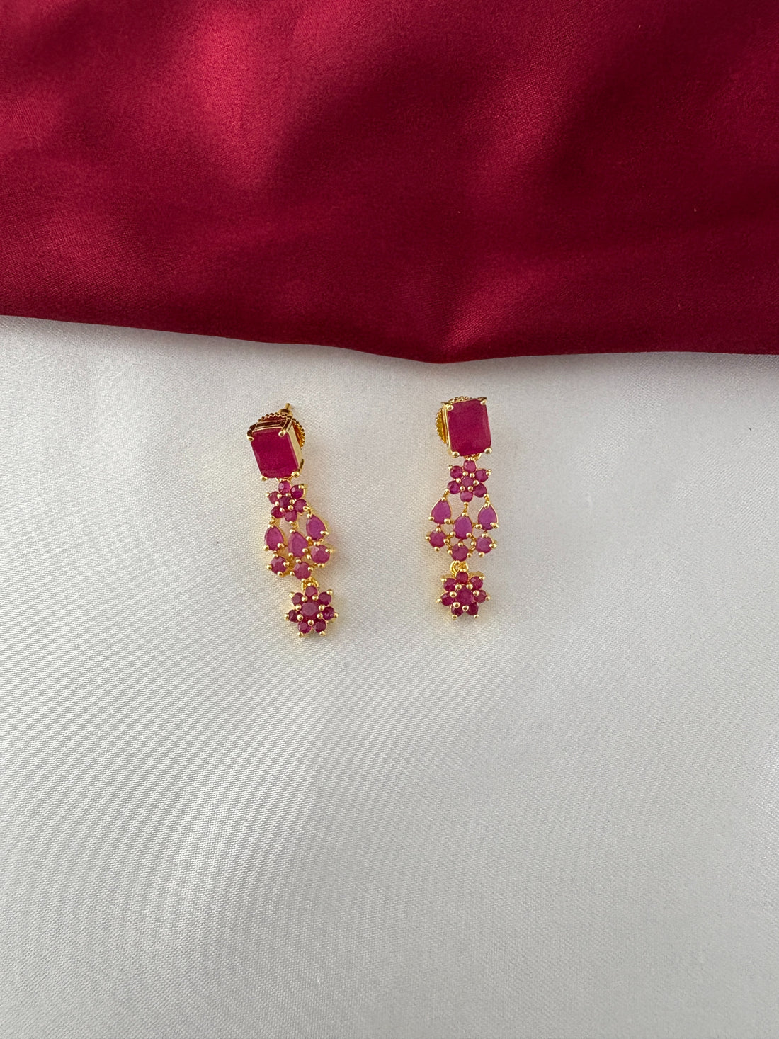 FeelOri Gold Plated Floral Ruby Earrings - Close-up view showcasing the rectangular stud and delicate dangling leaf-shaped ruby clusters.