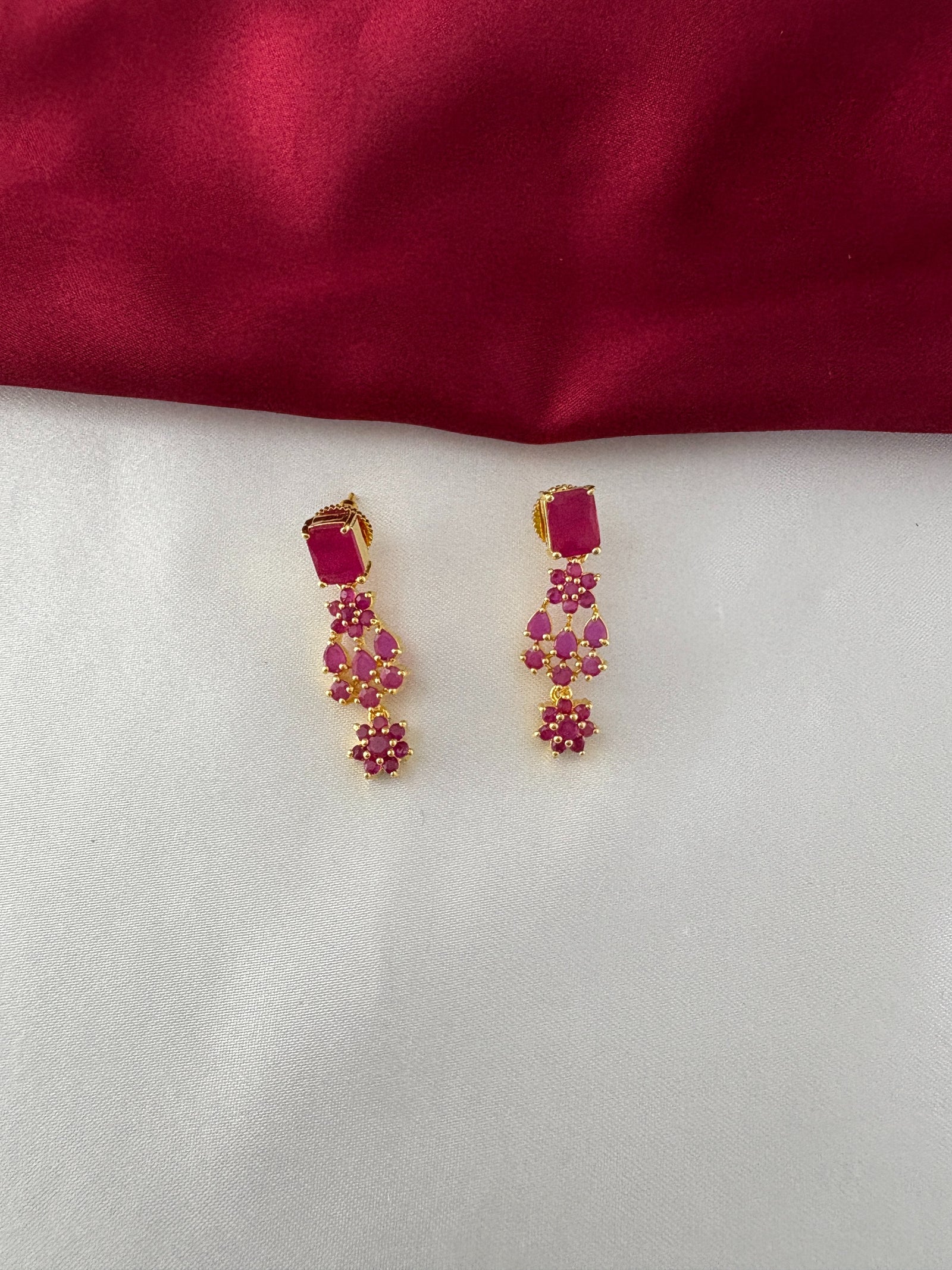 FeelOri Gold Plated Floral Ruby Earrings - Close-up view showcasing the rectangular stud and delicate dangling leaf-shaped ruby clusters.