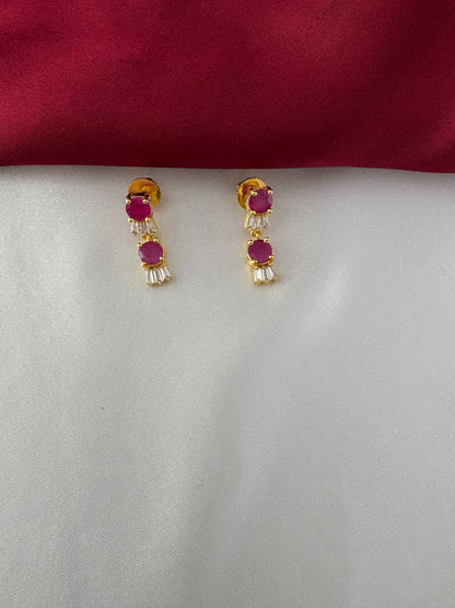 FeelOri Gold Plated Ruby Baguette Earrings - Detailed view of the matching drop earrings featuring three ruby hued circular stones and baguette clear stones.