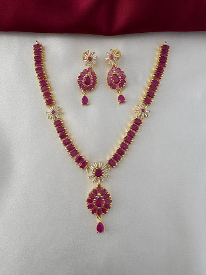 FeelOri Gold Plated Ruby Floral Cluster Necklace Set - Front view showcasing intricate necklace design with matching earrings on a white and maroon backdrop.