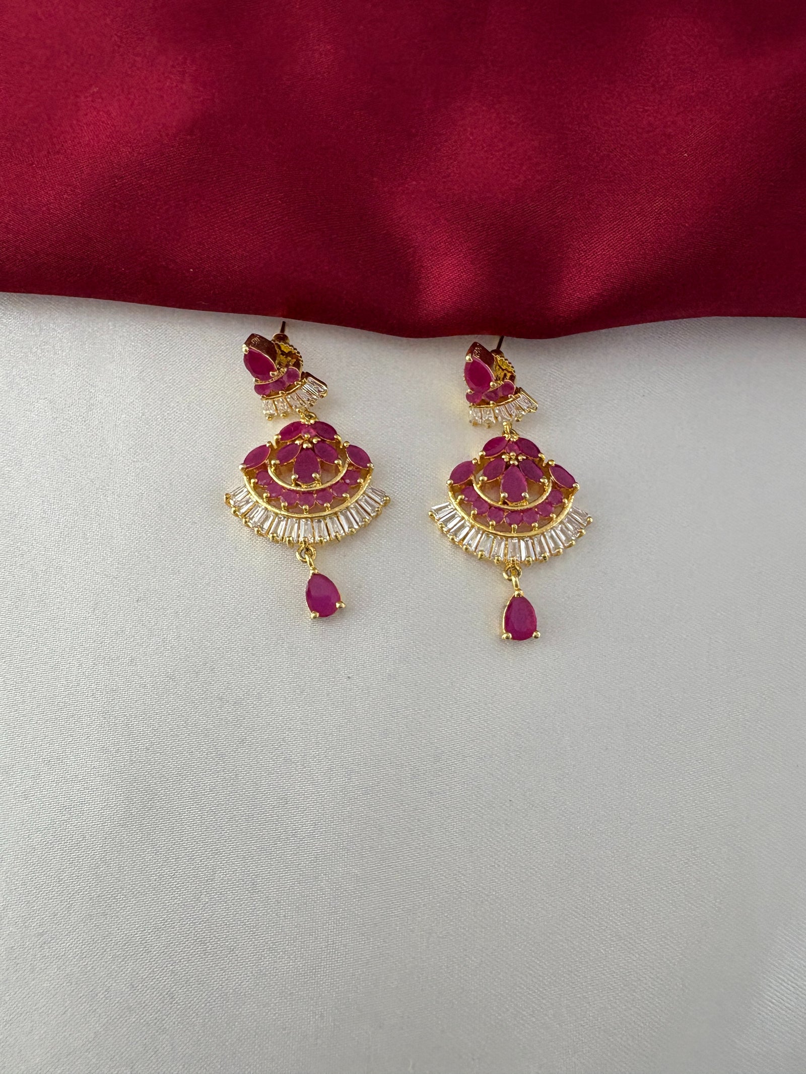 FeelOri Gold Plated Ruby & CZ Earrings - Close-up of the elegant fan-shaped earrings with dangle, featuring ruby-hued stones and baguette CZ detailing.