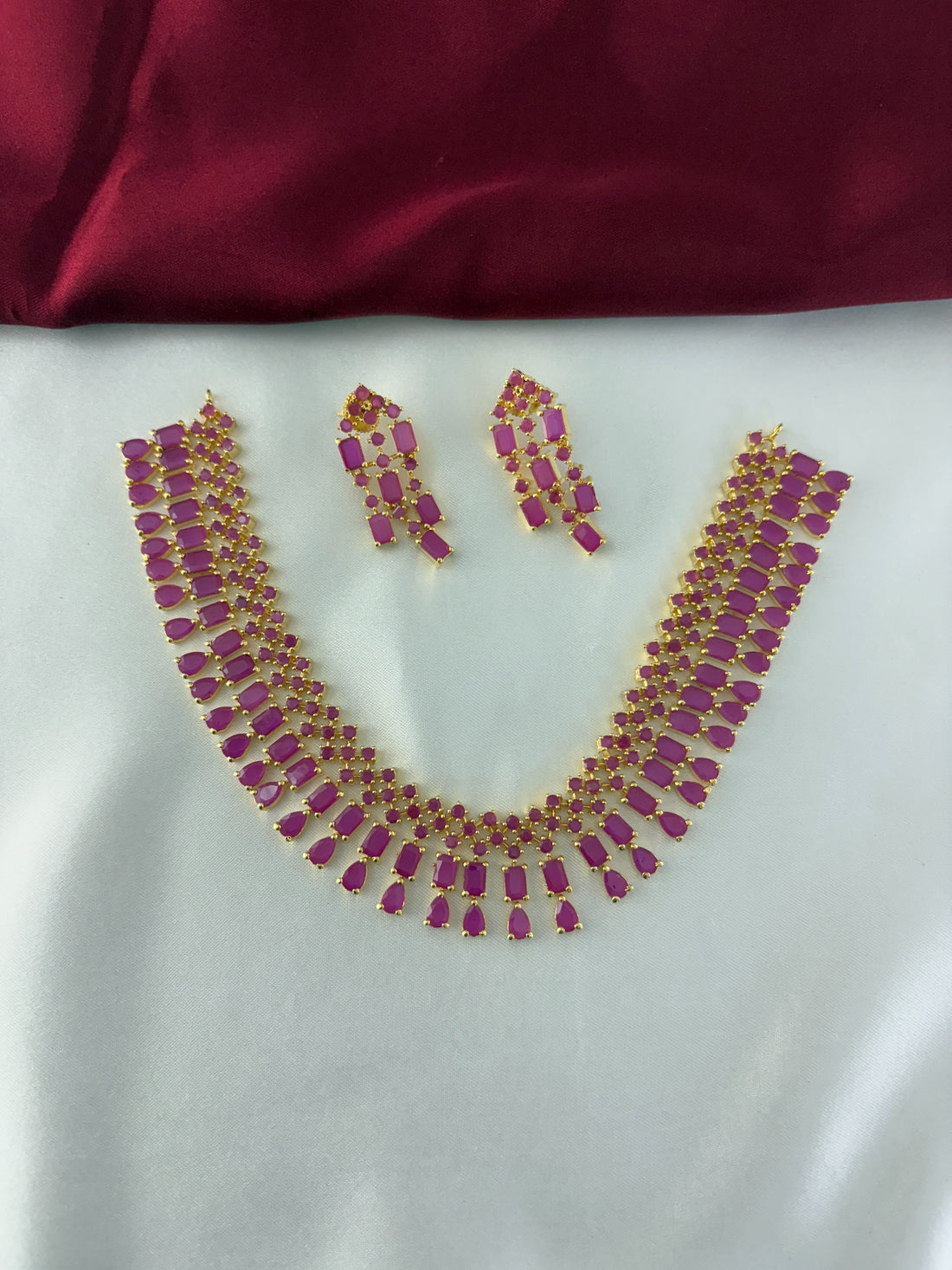 FeelOri Gold Plated Ruby Drop Kundan Necklace Set - Front view showcasing the complete set with interconnected ruby-hued stones.