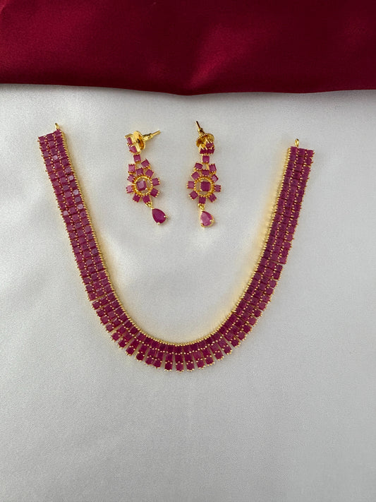 FeelOri Gold Plated Ruby Bar Necklace & Earring Set - Top view showcasing the full elegant set on a white silk backdrop.