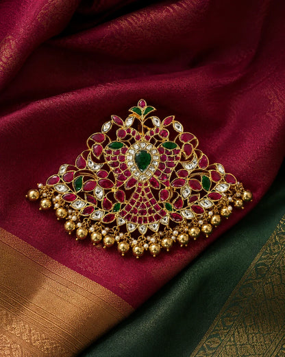 Broad twin-peacock Jadau Kundan pendant styled on maroon and green silk fabric