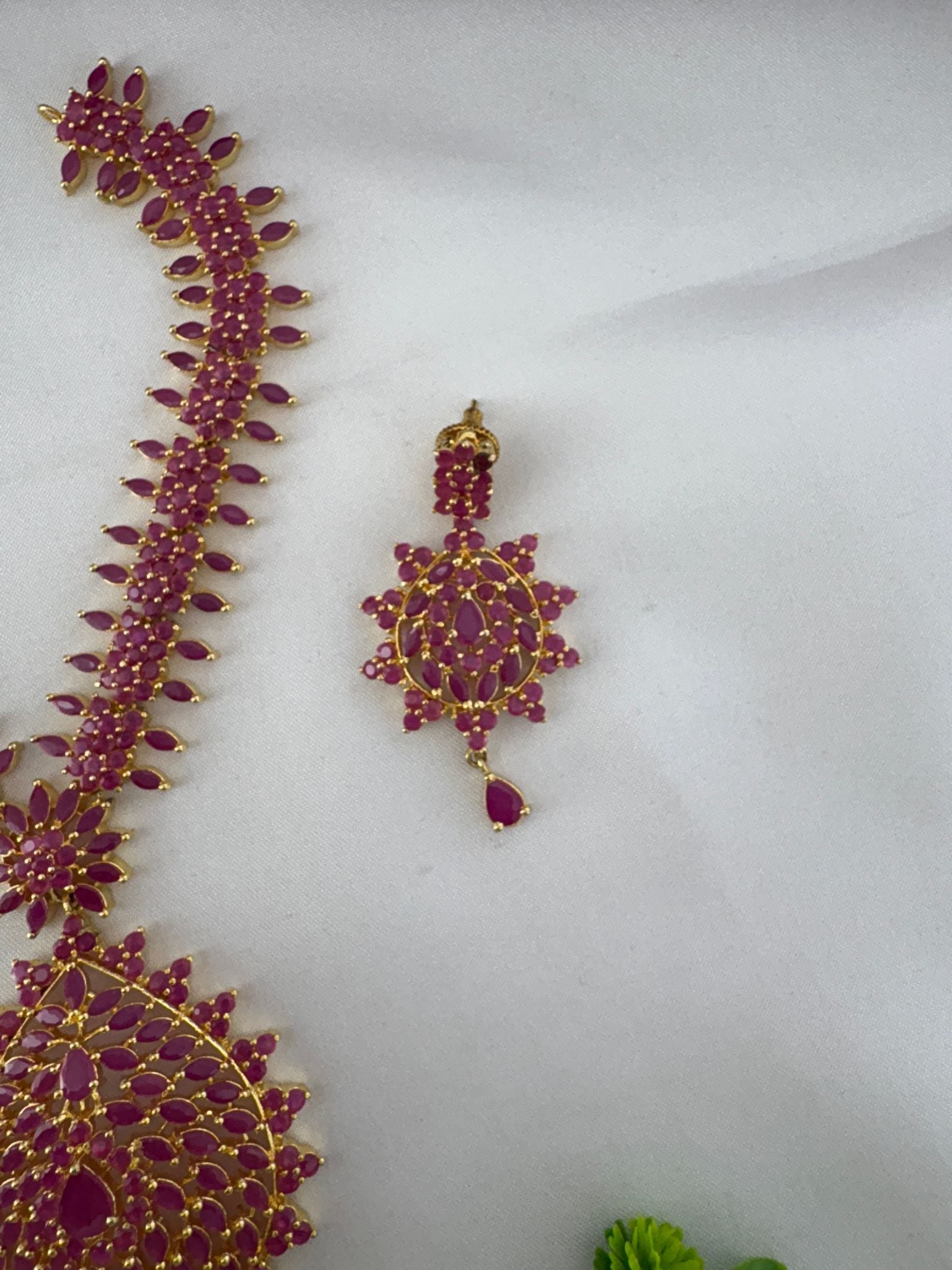 Detailed view of FeelOri Bold Statement Ruby-Tone CZ Necklace pendant and one earring, highlighting craftsmanship.