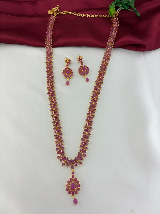 FeelOri Celestial Fire Ruby & AD Halo Long Necklace & Earring Set - Full view on maroon and white background.