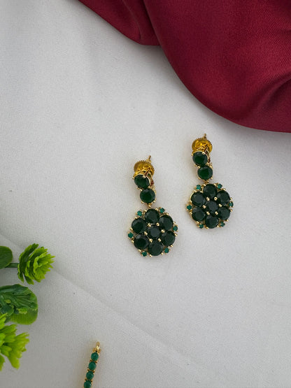 Detailed close-up of the FeelOri Deccan Spring Emerald earrings, showing the floral design and vibrant green stones, part of the necklace set.