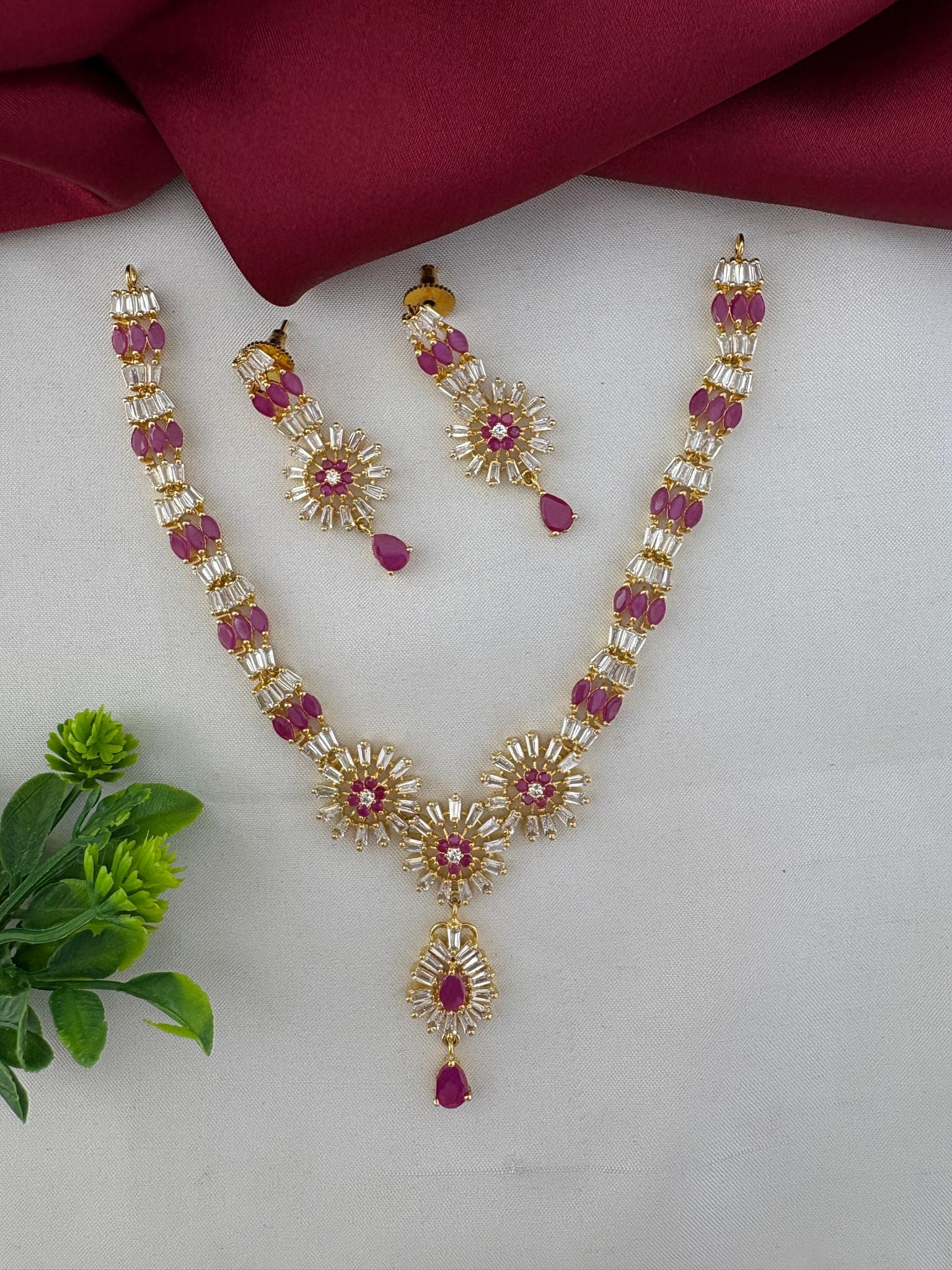 FeelOri Divine Ruby-Tone CZ Short Necklace Set - Temple Collection, elegant short necklace with matching drop earrings, ruby-colored and white stones, on a styled background.