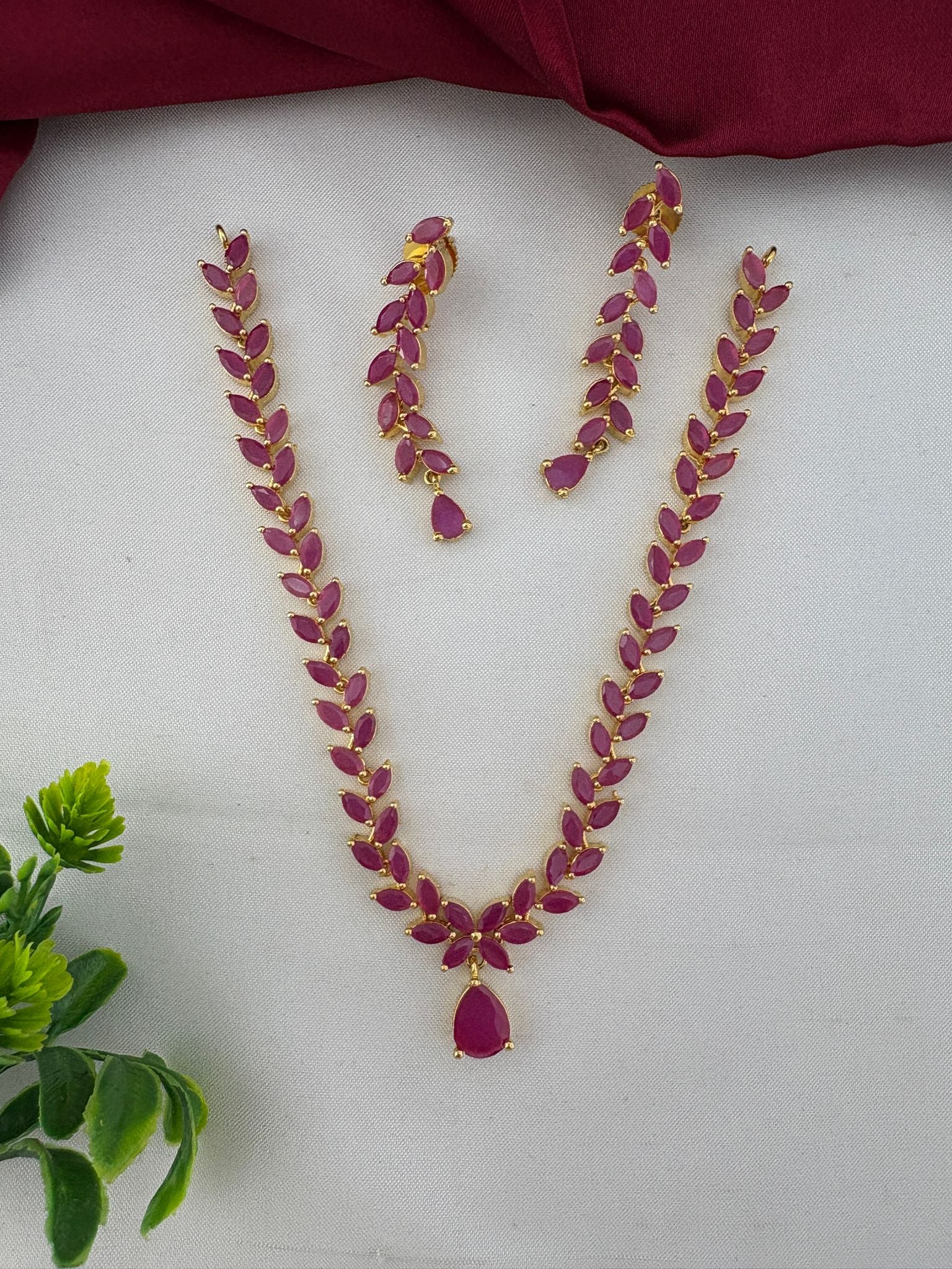 FeelOri Elegant Original Ruby Short Necklace and Earrings Set, styled with decorative element, perfect for Bangalore events. Gold plated design with vibrant ruby stones.