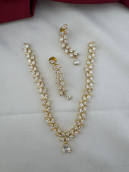 FeelOri Festive Dazzle AD Stone Floral Short Necklace Set with matching earrings, top view on a white fabric background.