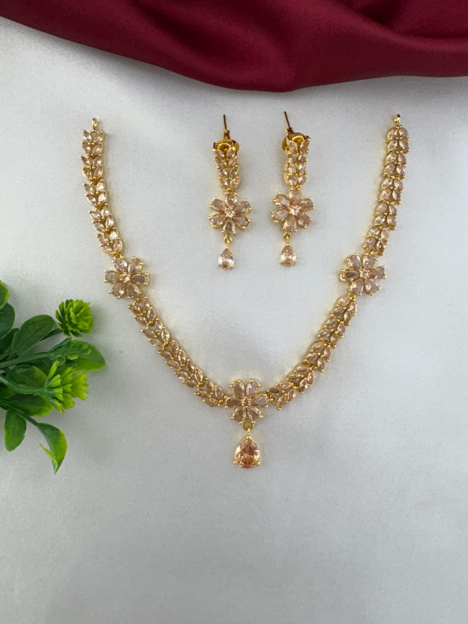 FeelOri Festive Sunbeam Gold AD Stone Short Set with floral necklace and matching earrings, top view.